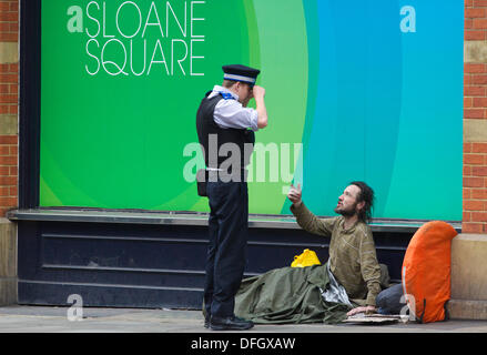 Obdachlosigkeit in UK, Sloane Square, London, England, UK 4. Oktober 2013.  Bild zeigt einen Mann auf der Straße angesprochen durch ein Polizist der Gemeinschaft wie Obdachlosigkeit in Großbritannien einen Fünf-Jahres-hoch erreicht hat, wie gesetzliche Obdachlose Zahlen deuten darauf hin, dass die häufigste Grund für immer heimatlos war, weil Eltern, Verwandte oder Freunde nicht mehr waren in der Lage oder bereit sind, für Personen schlafen. London hatte die größte Anzahl von groben Schwellen bei 557, die entfielen 24 % des gesamten in ganz Großbritannien. Bildnachweis: Jeff Gilbert/Alamy Live-Nachrichten Stockfoto