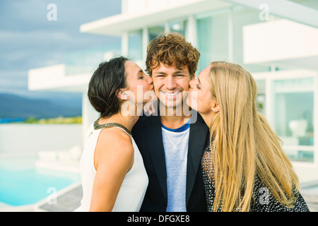 Frauen im freien Mannes Wangen küssen Stockfoto