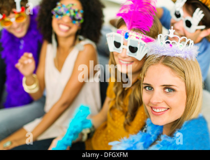 Freunde tragen dekorative Gläser und Kronen auf party Stockfoto