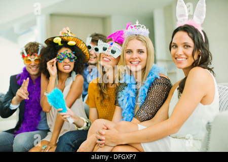 Freunde tragen dekorative Gläser und Kopfbedeckungen auf party Stockfoto