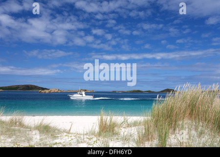 Kleines weißes Boot im türkisblauen Meer vor Tresco Isles of Scilly, Cornwall UK Stockfoto