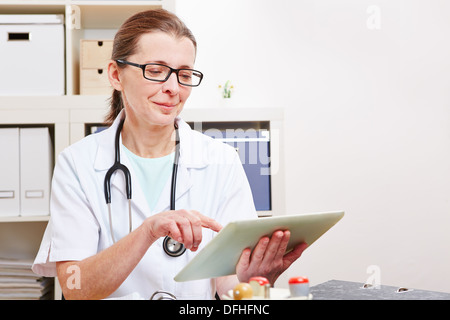 Leitende Ärztin mit einem Tabletcomputer in ihrem Büro Stockfoto