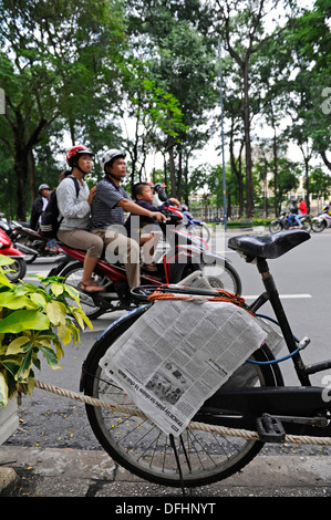 Familiengruppe, Reiten auf einem Motorrad oder moped auf einer belebten Straße in Ho-Chi-Minh-Stadt. Stockfoto