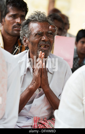 Indischer Mann im Gebet während der Wartezeit auf Sri Sathya Sai Baba mobile aufsuchende Krankenhaus zu sehen. Andhra Pradesh, Indien Stockfoto
