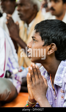 Indianerjunge im Gebet während der Wartezeit auf Sri Sathya Sai Baba mobile aufsuchende Krankenhaus zu sehen. Andhra Pradesh, Indien Stockfoto