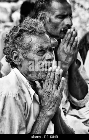 Indische Männer im Gebet während der Wartezeit auf Sri Sathya Sai Baba mobile aufsuchende Krankenhaus zu sehen. Andhra Pradesh, Indien Stockfoto
