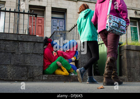 Bangor, Wales, UK. 5. Okt, erstellen 2013,20 bunt gekleidete junge Interpreten bunte statische Bilder, wie sie ihren Körper in Räume und Hohlräume in der Stadt Bangor in Nordwales einfügen. Österreichische Choreograf WILLI DORNER ersonnen, ist "Einrichtungen im urbanen Raum" eine weltweite Reisen Performance mit lokalen Tänzer und Turner. gequetscht und ausgewogen unter Architektur der Stadt. Hunderte von Menschen folgten ihren Fortschritt durch die Stadt auf eine einstündige kostenlose Leistung. Bildnachweis: Keith Morris/Alamy Live-Nachrichten Stockfoto