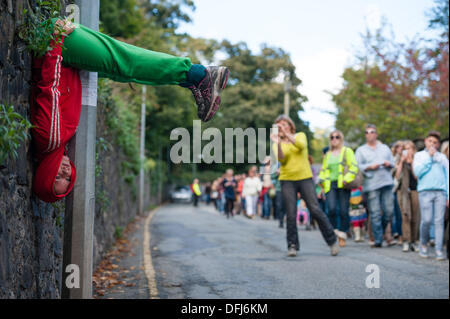 Bangor, Wales, UK. 5. Okt, erstellen 2013,20 bunt gekleidete junge Interpreten bunte statische Bilder, wie sie ihren Körper in Räume und Hohlräume in der Stadt Bangor in Nordwales einfügen. Österreichische Choreograf WILLI DORNER ersonnen, ist "Einrichtungen im urbanen Raum" eine weltweite Reisen Performance mit lokalen Tänzer und Turner. gequetscht und ausgewogen unter Architektur der Stadt. Hunderte von Menschen folgten ihren Fortschritt durch die Stadt auf eine einstündige kostenlose Leistung. Bildnachweis: Keith Morris/Alamy Live-Nachrichten Stockfoto