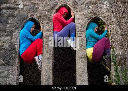 Bangor, Wales, UK. 5. Okt, erstellen 2013,20 bunt gekleidete junge Interpreten bunte statische Bilder, wie sie ihren Körper in Räume und Hohlräume in der Stadt Bangor in Nordwales einfügen. Österreichische Choreograf WILLI DORNER ersonnen, ist "Einrichtungen im urbanen Raum" eine weltweite Reisen Performance mit lokalen Tänzer und Turner. gequetscht und ausgewogen unter Architektur der Stadt. Hunderte von Menschen folgten ihren Fortschritt durch die Stadt auf eine einstündige kostenlose Leistung. Bildnachweis: Keith Morris/Alamy Live-Nachrichten Stockfoto