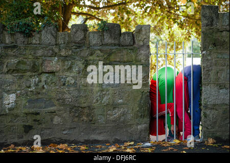 Bangor, Wales, UK. 5. Okt, erstellen 2013,20 bunt gekleidete junge Interpreten bunte statische Bilder, wie sie ihren Körper in Räume und Hohlräume in der Stadt Bangor in Nordwales einfügen. Österreichische Choreograf WILLI DORNER ersonnen, ist "Einrichtungen im urbanen Raum" eine weltweite Reisen Performance mit lokalen Tänzer und Turner. gequetscht und ausgewogen unter Architektur der Stadt. Hunderte von Menschen folgten ihren Fortschritt durch die Stadt auf eine einstündige kostenlose Leistung. Bildnachweis: Keith Morris/Alamy Live-Nachrichten Stockfoto