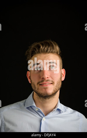 Hübscher junger Mann mit schönen Ausdruck, große textfreiraum nachschlagen auf schwarzem Hintergrund isoliert Stockfoto