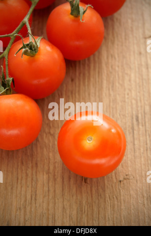 Cherry-Tomaten auf einem rustikalen Holztisch Stockfoto