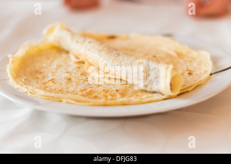 Gefüllte Crêpe aufgerollt, auf einem Teller Stockfoto