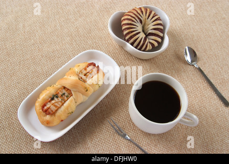 Schmackhafte Wurst Brot und Kaffee auf einem Stoff-Hintergrund Stockfoto