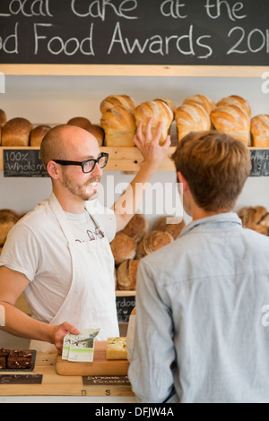 Eine handwerkliche Bäckerei in Bristol mit Großbritanniens erste Stadt breit lokalen Währung das Bristol-Pfund - ein Kunde zahlt mit lokaler note Stockfoto