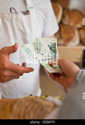 Eine handwerkliche Bäckerei in Bristol mit Großbritanniens erste Stadt breit lokalen Währung das Bristol-Pfund - ein Kunde zahlt mit lokaler note Stockfoto