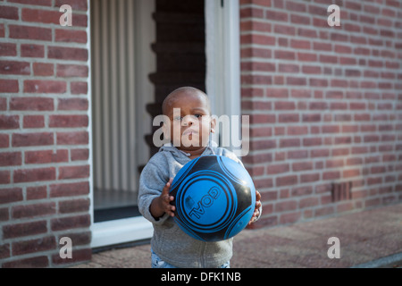 Porträt eines jungen Mannes mit einem Fußball in eines der Viertel von Eindhoven in den Niederlanden Stockfoto