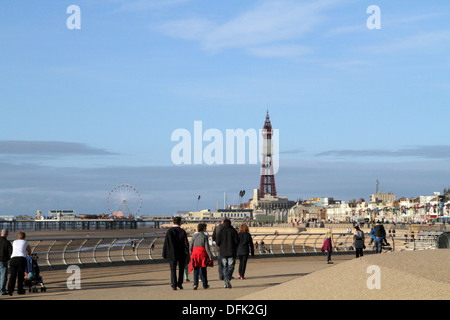 Menschen, die ein Spaziergang entlang der Promenade in Richtung Blackpool Tower an einem sonnigen Tag Stockfoto