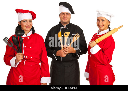 Glückliches Team der drei Köche mit Küchenutensilien, die isoliert auf weißem Hintergrund Stockfoto
