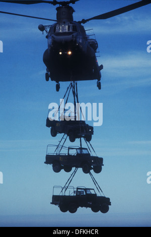 Eine RAF Boeing Chinook-Hubschrauber heben ein Trio von alten Landrover auf den Falkland-Inseln Stockfoto