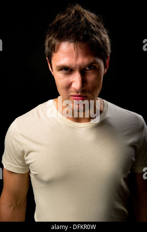 Porträt eines schön wütend auf schwarzem Hintergrund Stockfoto