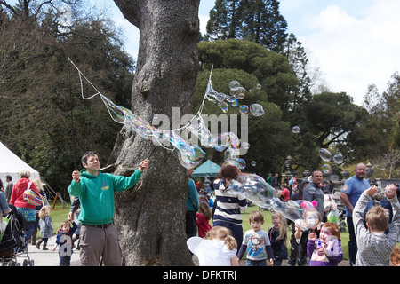 Man Luftblasen machen unterhaltsame Kindern in Margam Park, South Wales UK. Stockfoto