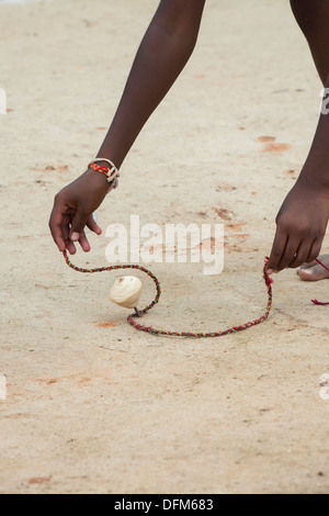 Indische Bauerndorf junge mit hölzernen Spinning Top Spielzeug spielen. Andhra Pradesh, Indien Stockfoto