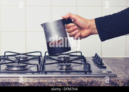 Hand des Mannes platzieren Moka Topf auf Herd Stockfoto