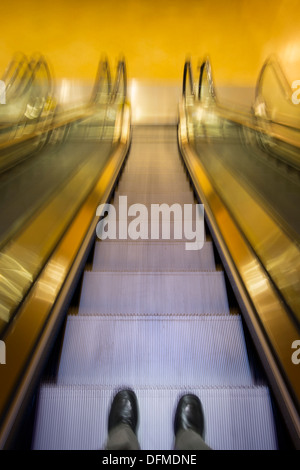 Das Unternehmer Füße Rolltreppe hinunter Stockfoto