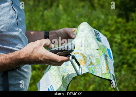 Mann mit einem GPS-Empfänger und Plan in der hand Stockfoto