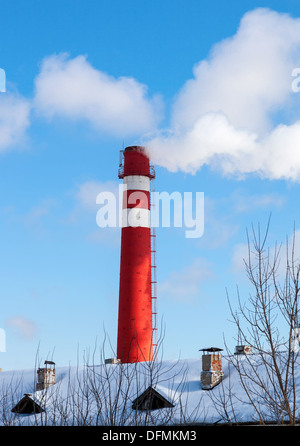 Rote Fabrikschornstein gegen blauen Himmel im winter Stockfoto