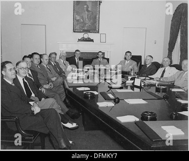 Ein Foto von einer Kabinettssitzung des Weißen Hauses, das Schlüsselfiguren der US-Regierung zeigt, darunter Landwirtschaftsminister Clinton P. Anderson und andere Beamte. Dieses Treffen stellt die Entscheidungsfindung der Regierung während der politischen Geschichte der Mitte des 20. Jahrhunderts dar. Stockfoto