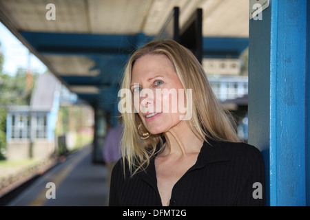 Frau wartet auf ihren Zug auf der Plattform der s-Bahn-Station in den Vororten von New York City, New York, USA Stockfoto