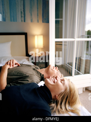 Paar auf ein Doppelbett in einem Hotelzimmer liegen, Spa resort, Travemünde, Lübeck, Schleswig-Holstein, Deutschland Stockfoto