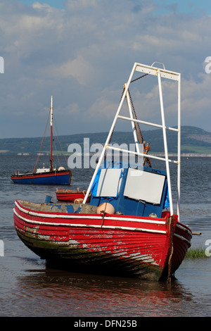 Einem alten roten und blauen Fischerboot am Strand von Morecambe Bay bei Ebbe Stockfoto