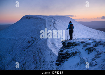 Weibliche Wanderer sieht in Richtung Pen Y Fan im Morgengrauen aus Mais Du, Brecon Beacons National Park, Wales Stockfoto