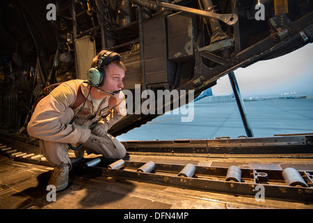 Senior Airman Zac Sidders, 774th Expeditionary Airlift Squadron c-130 Hercules Loadmaster, Spots für Verkehr beim Rückwärtsfahren aus einem Parkplatz bei Bagram Airfield, Afghanistan, 28. September 2013. Diese Mission war ein retrograden Meilenstein als 774th EAS Stockfoto