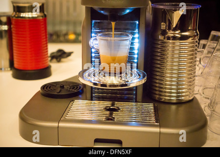 Ein Nespresso Marke einschüssigen Kaffee Brauer gießt einen Espresso an einer Werbeveranstaltung in New York Stockfoto