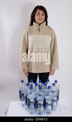 Teenager-Mädchen posiert mit 12 Plastikflaschen zu illustrieren, das recycling von Flaschen in einer Polyester-fleece Stockfoto