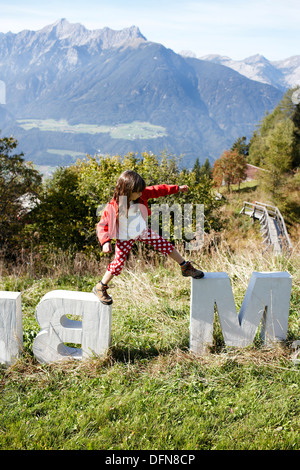 Mädchen Gleichgewichtsübungen auf konkrete Buchstaben in der Nähe von Ecohotel Grafenast bin Hochpillberg, Schwaz, Tirol, Österreich Stockfoto