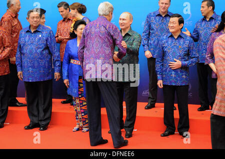 US-Außenminister John Kerry grüßt der russische Präsident Vladimir Putin, bevor das Familienfoto in einem traditionellen Batik t-Shirts vor dem APEC Führer Abendessen 7. Oktober 2013 in Bali, Indonesien gekleidet. Stockfoto