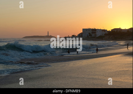 Menschen am Strand bei Sonnenuntergang, Cabo de Trafalgar im Hintergrund, Los Canos de Meca, Andalusien, Spanien, Europa Stockfoto