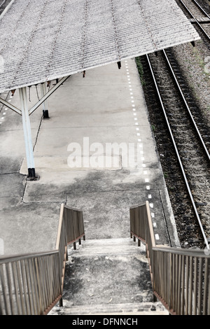 Es ist ein Foto von einem Bahnhof oder Bahnhof in Bangkok in Thailand. Wir sehen eine Fußgängerbrücke über die Plattform Stockfoto