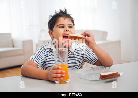 Junge Essen Toast mit Orangensaft Stockfoto