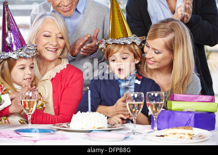 Fröhlicher Junge feiert Geburtstag mit seiner Familie und seinen Großeltern Stockfoto