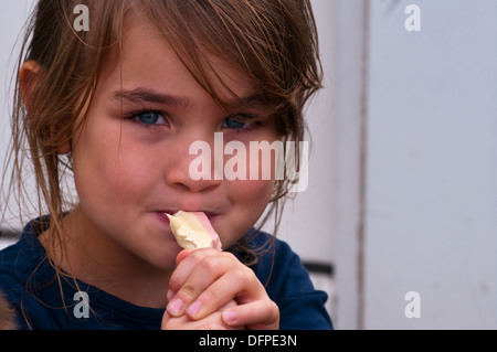 Kleine Mädchen essen eine zähe süße Stockfoto