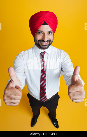 Erhöhte Ansicht eines Geschäftsmannes zeigt Daumen hoch Zeichen und lächelnd Stockfoto