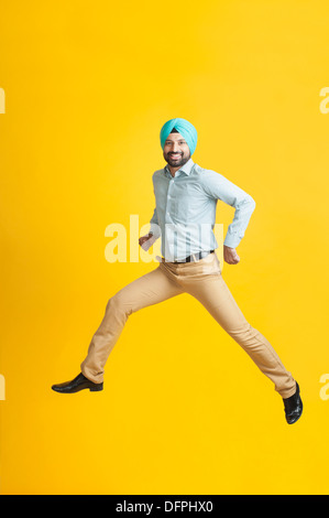 Aufgeregt Sikh Mann springen und lächelnd Stockfoto