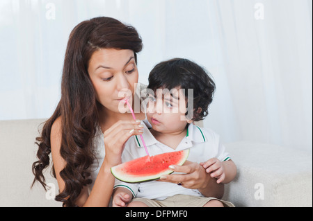 Frau saugt Saft aus Wassermelone Stockfoto