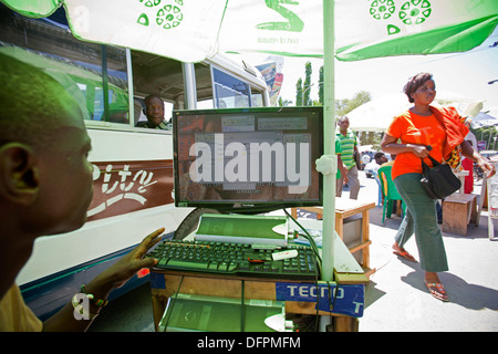 Straßenstand unter einem Sonnenschirm mit einem Desktop-Computer Verkauf von illegalen MP3 Musik downloads, Kariakoo, Dar Es Salaam, Tansania. Stockfoto